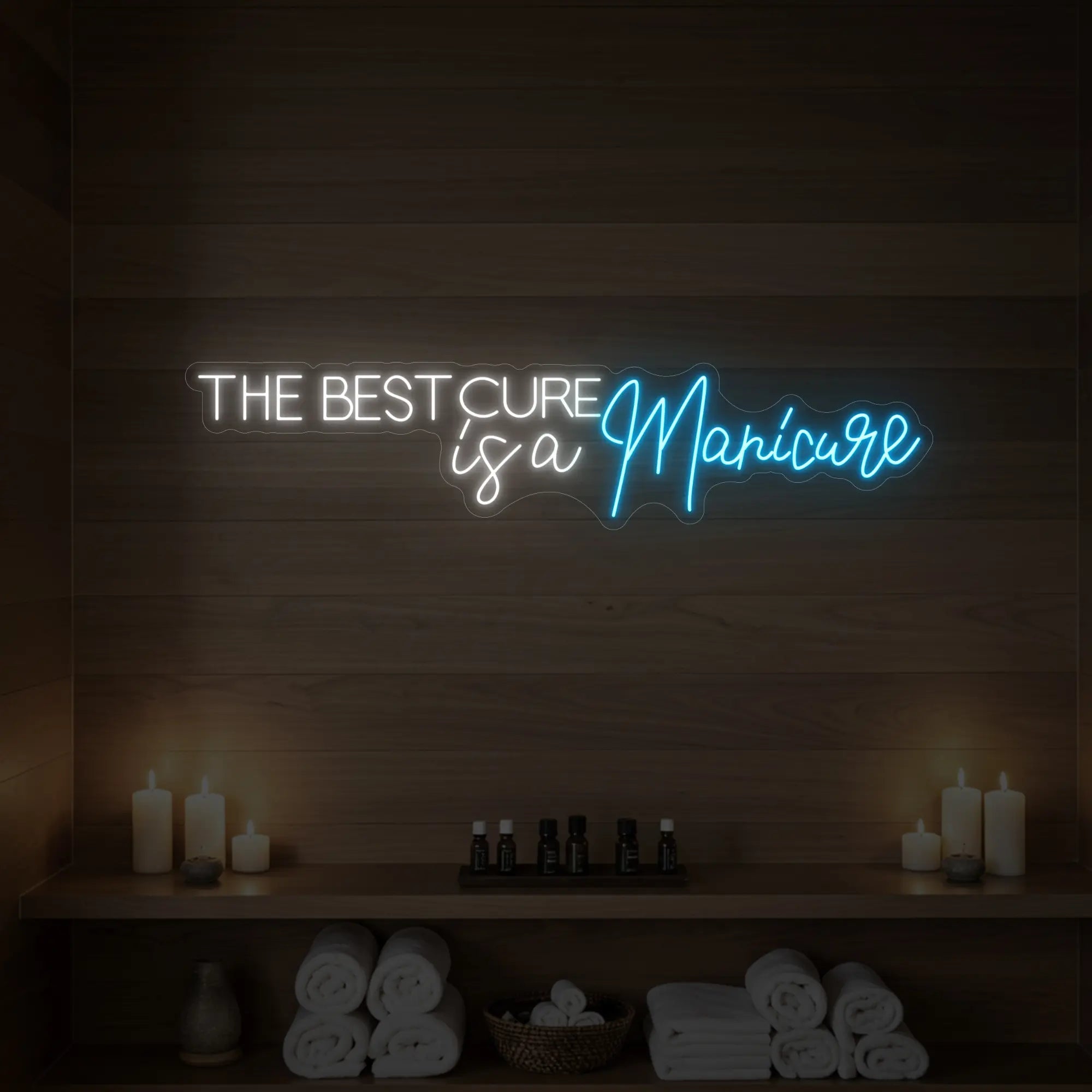 Photo of the 'The Best Cure is a Manicure' neon sign glowing in ice blue against a styled interior wall.
