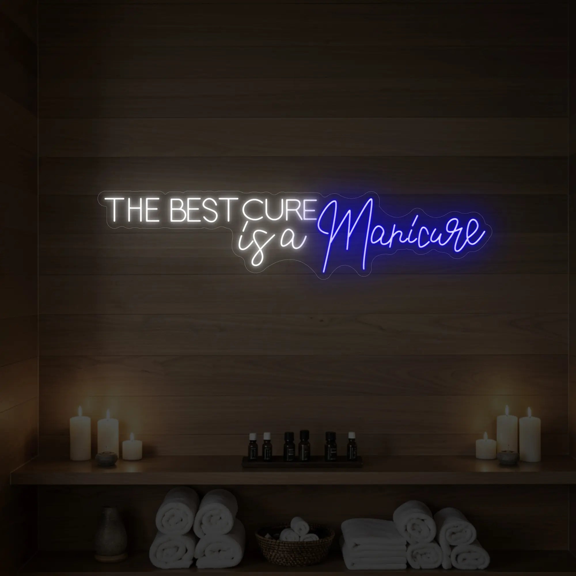 Photo of the 'The Best Cure is a Manicure' neon sign glowing in deep blue against a styled interior wall.