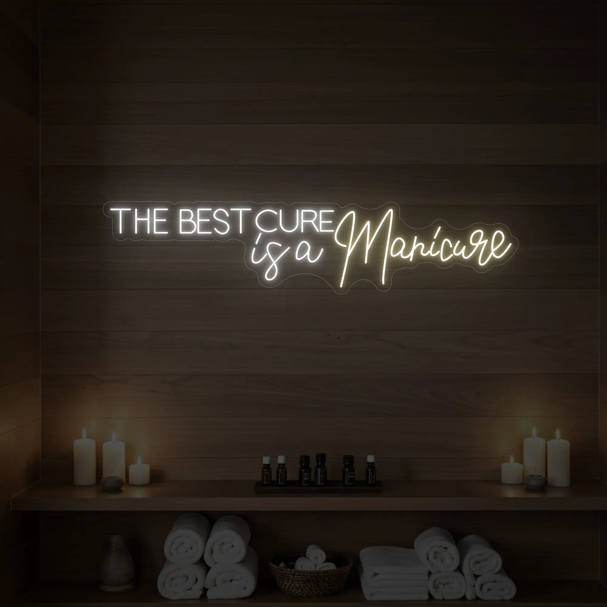 Photo of the 'The Best Cure is a Manicure' neon sign glowing in warm white against a styled interior wall.