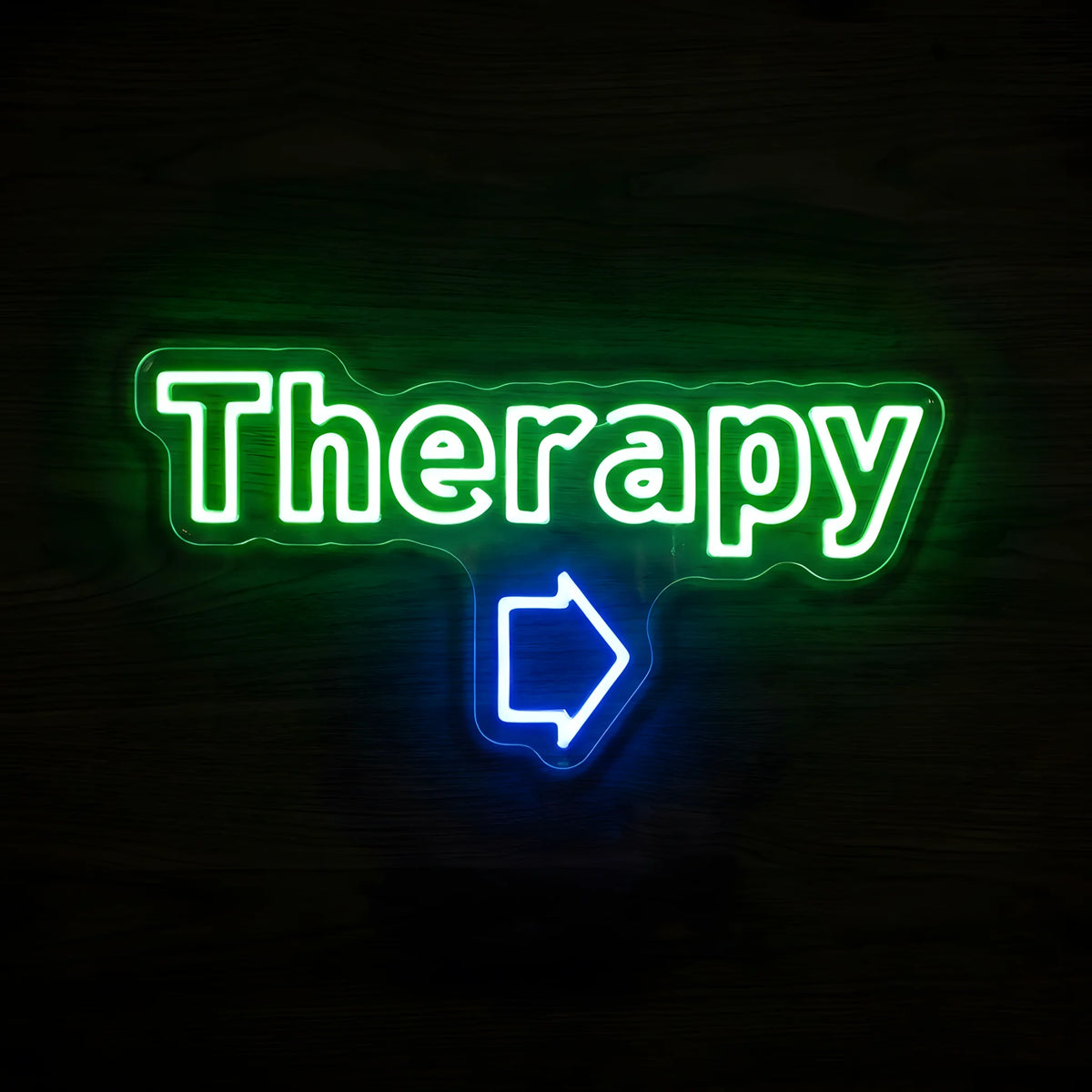 Therapy LED neon sign with green lettering and blue arrow on clear acrylic backing for physical therapy clinic and healthcare wall decor.