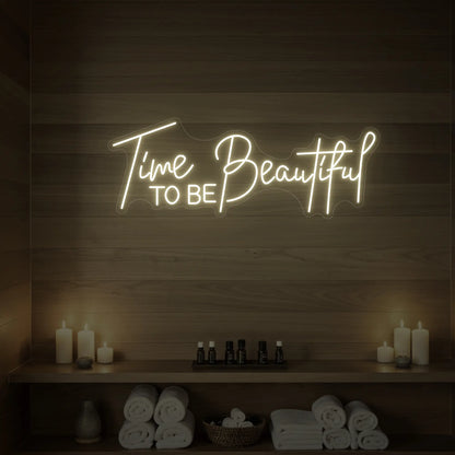 Photo of the 'TIME TO BE BEAUTIFUL' neon sign glowing in warm white against a styled interior wall.