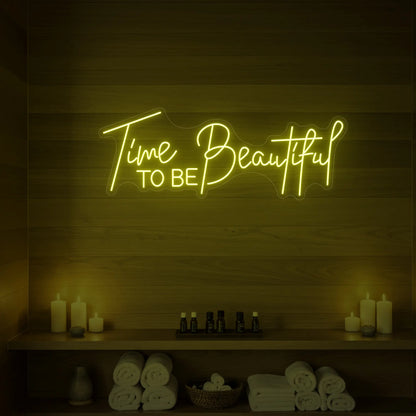 Photo of the 'TIME TO BE BEAUTIFUL' neon sign glowing in green against a styled interior wall.