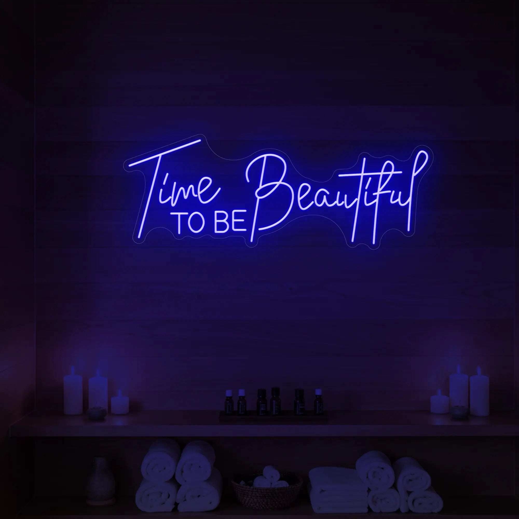 Photo of the 'TIME TO BE BEAUTIFUL' neon sign glowing in deep blue against a styled interior wall.