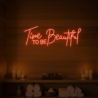 Photo of the 'TIME TO BE BEAUTIFUL' neon sign glowing in golden yellow against a styled interior wall.