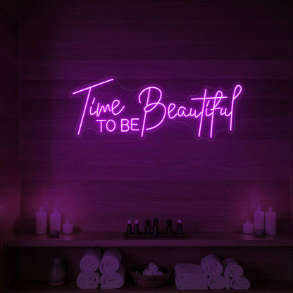 Photo of the 'TIME TO BE BEAUTIFUL' neon sign glowing in deep pink against a styled interior wall.