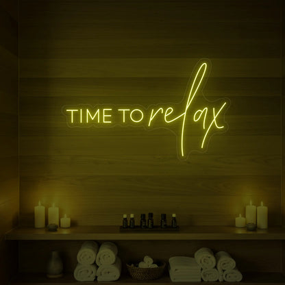 Photo of the 'TIME TO RELAX' neon sign glowing in lemon yellow against a styled interior wall.