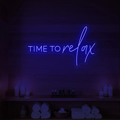 Photo of the 'TIME TO RELAX' neon sign glowing in deep blue against a styled interior wall.
