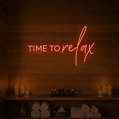 Photo of the 'TIME TO RELAX' neon sign glowing in golden yellow against a styled interior wall.