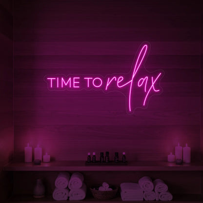 Photo of the 'TIME TO RELAX' neon sign glowing in light pink against a styled interior wall.