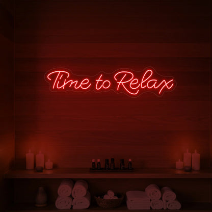 Photo of the 'Time to Relax' neon sign glowing in red against a styled interior wall.