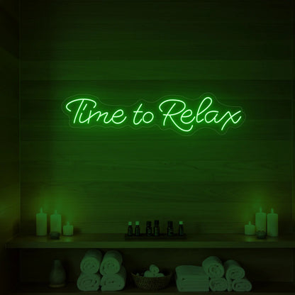 Photo of the 'Time to Relax' neon sign glowing in green against a styled interior wall.