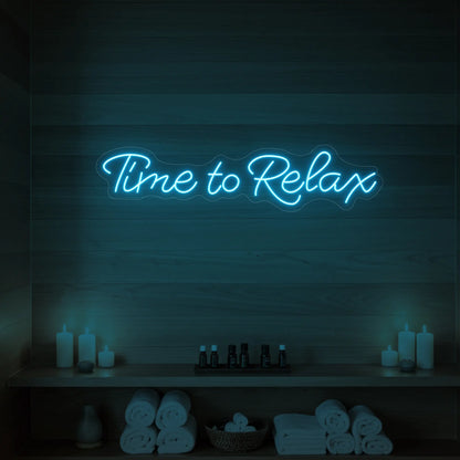 Photo of the 'Time to Relax' neon sign glowing in ice blue against a styled interior wall.