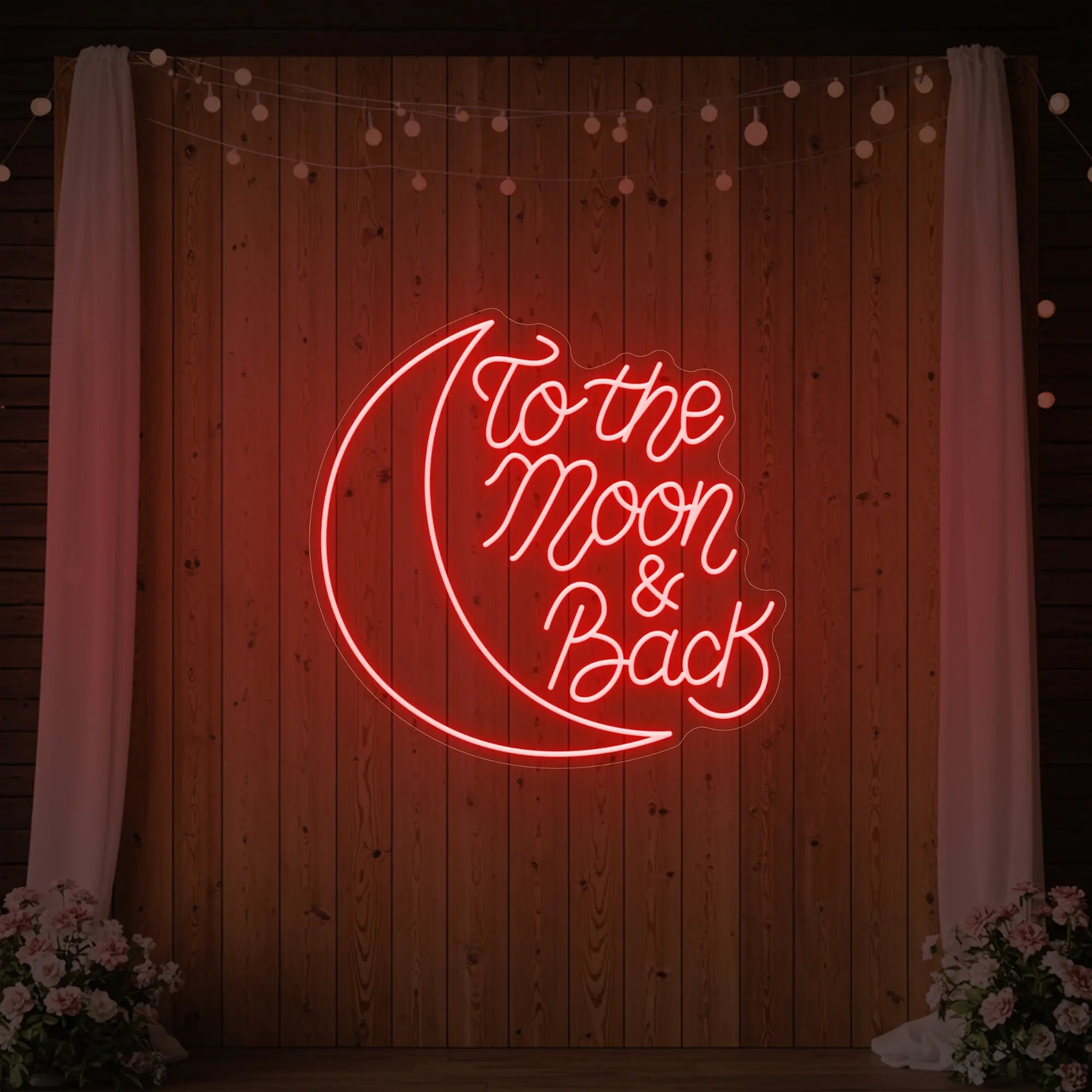  'To The Moon & Back' neon sign glowing in red against a styled interior wall.