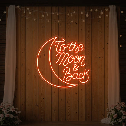 'To The Moon & Back' neon sign glowing in golden yellow against a styled interior wall.