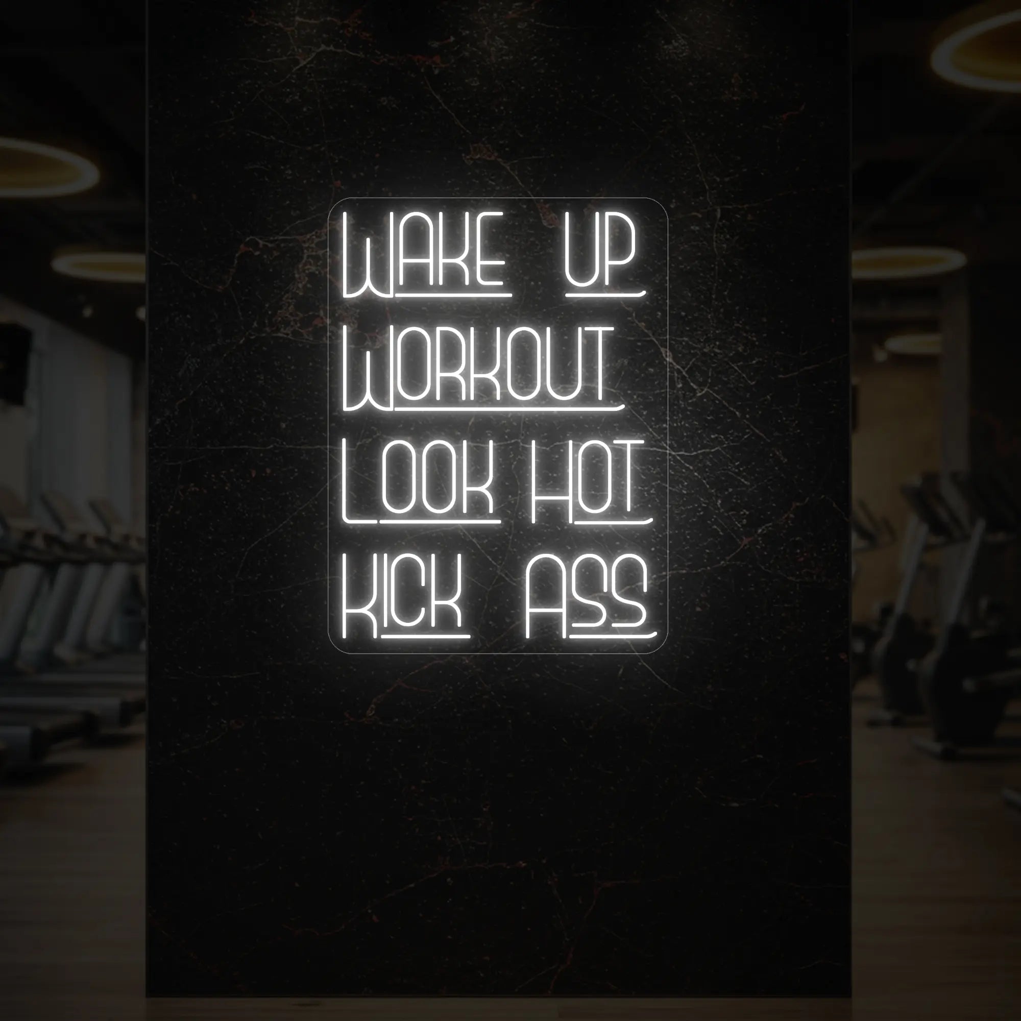  'WAKE UP WORKOUT LOOK HOT KICK ASS' neon sign glowing in cool white against a styled interior wall.