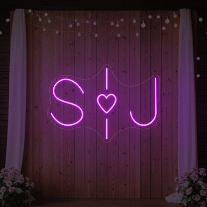 Photo of the 'Wedding Initials Custom Neon Sign V6' neon sign glowing in deep pink against a styled interior wall.