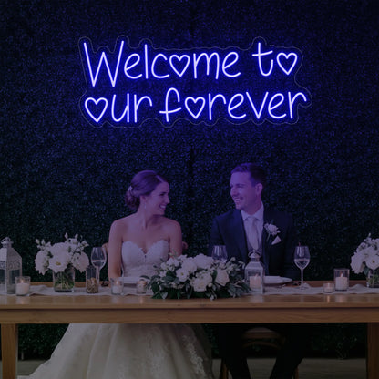  'Welcome To Our Forever' neon sign glowing in deep blue against a styled interior wall.
