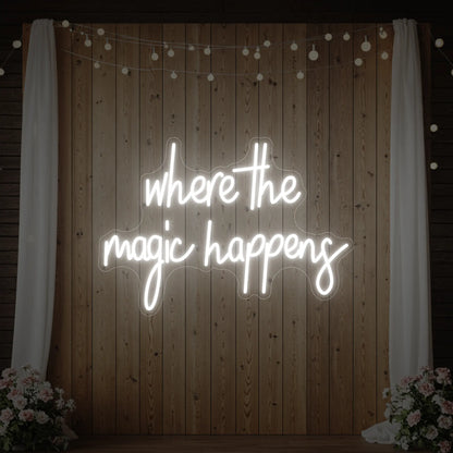  'Where The Magic Happens' neon sign glowing in cool white against a styled interior wall.