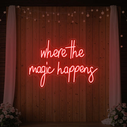  'Where The Magic Happens' neon sign glowing in red against a styled interior wall.