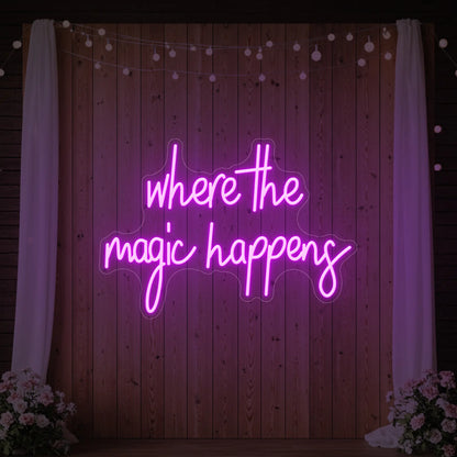  'Where The Magic Happens' neon sign glowing in deep pink against a styled interior wall.