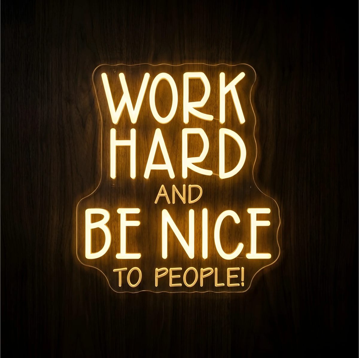 “WORK HARD AND BE NICE TO PEOPLE!” LED Neon Sign with warm yellow lettering on clear acrylic backing against a dark wood background, suitable for offices, classrooms, and reception areas.