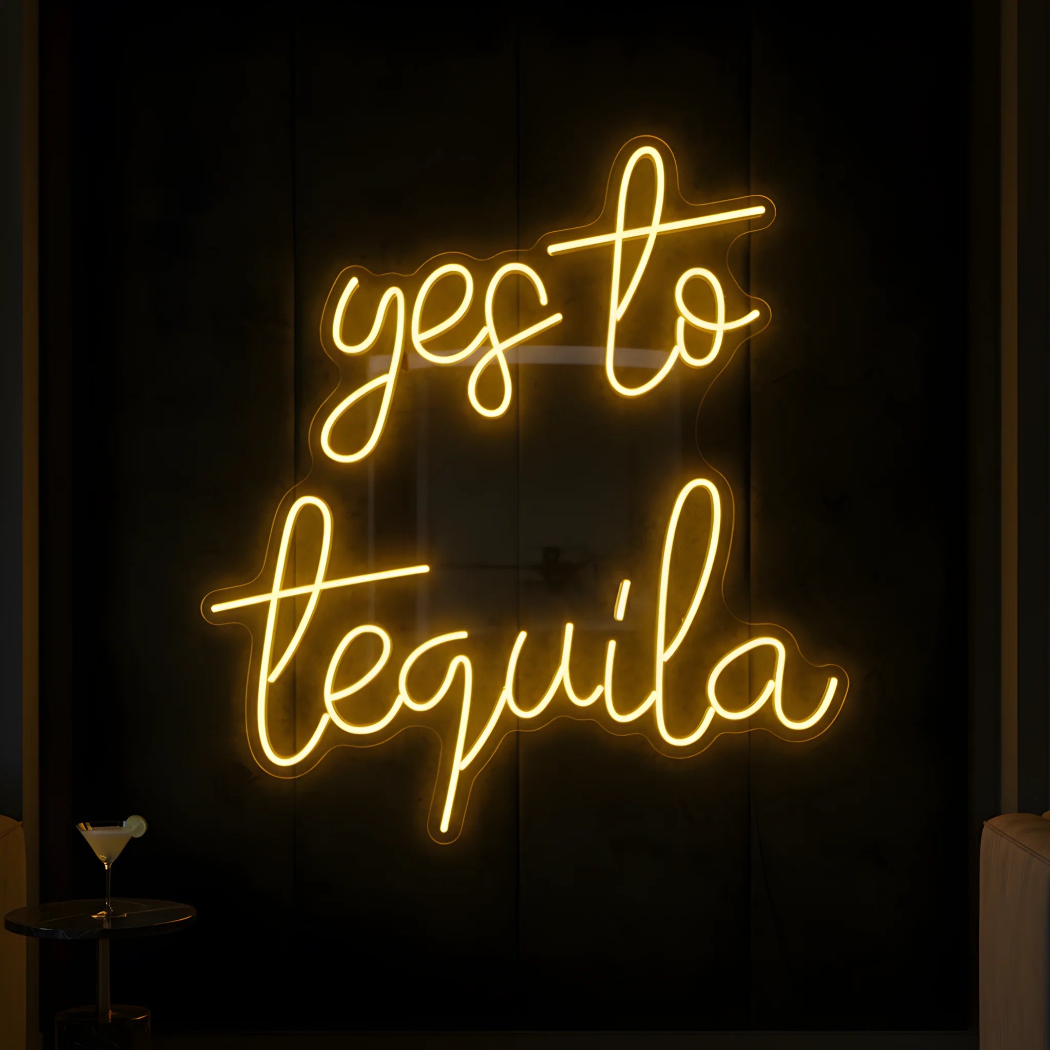Photo of the 'Yes to Tequila' neon sign glowing in yellow against a tequila bar-inspired wall.