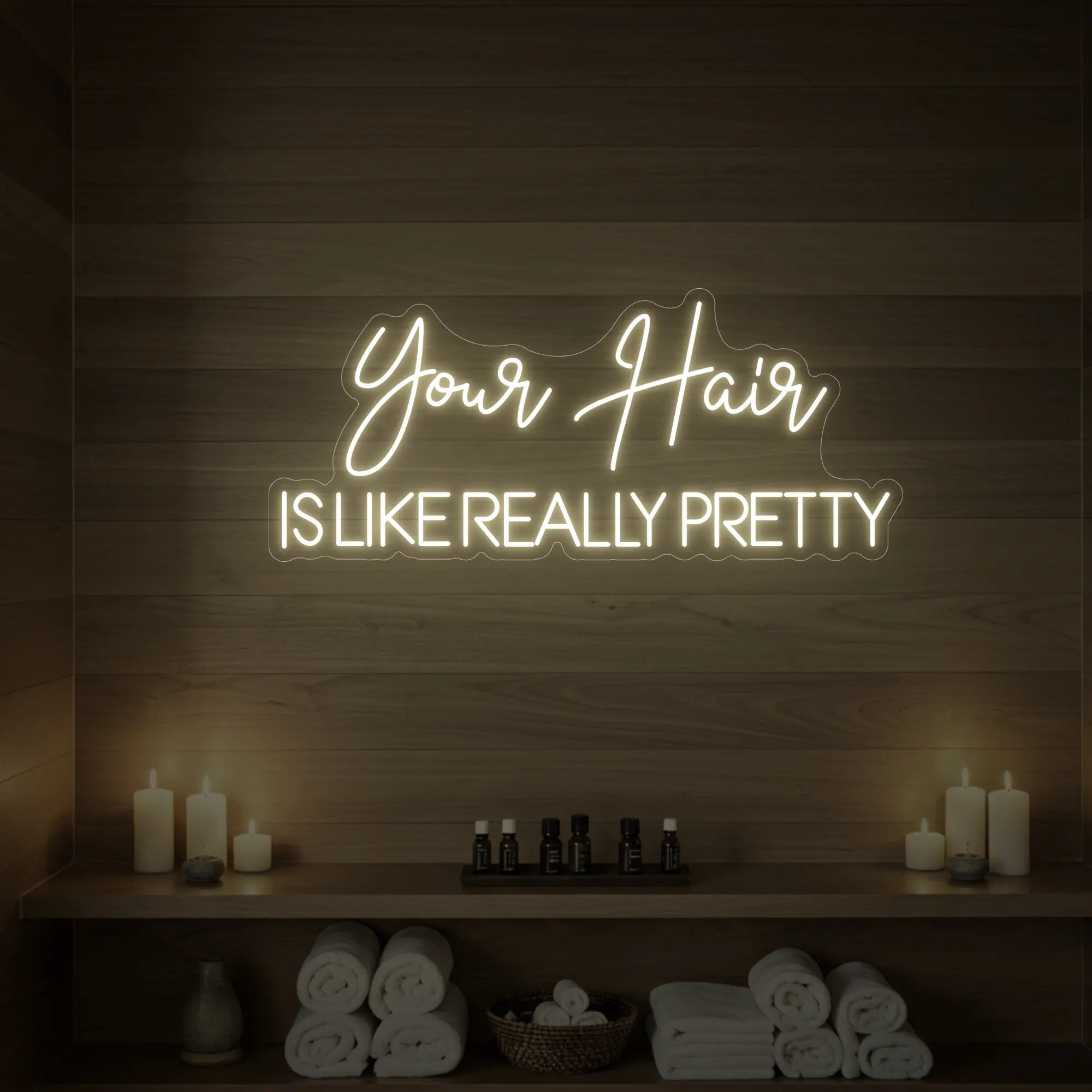 Photo of the 'Your Hair Is Like Really Pretty' neon sign glowing in warm white against a styled interior wall.