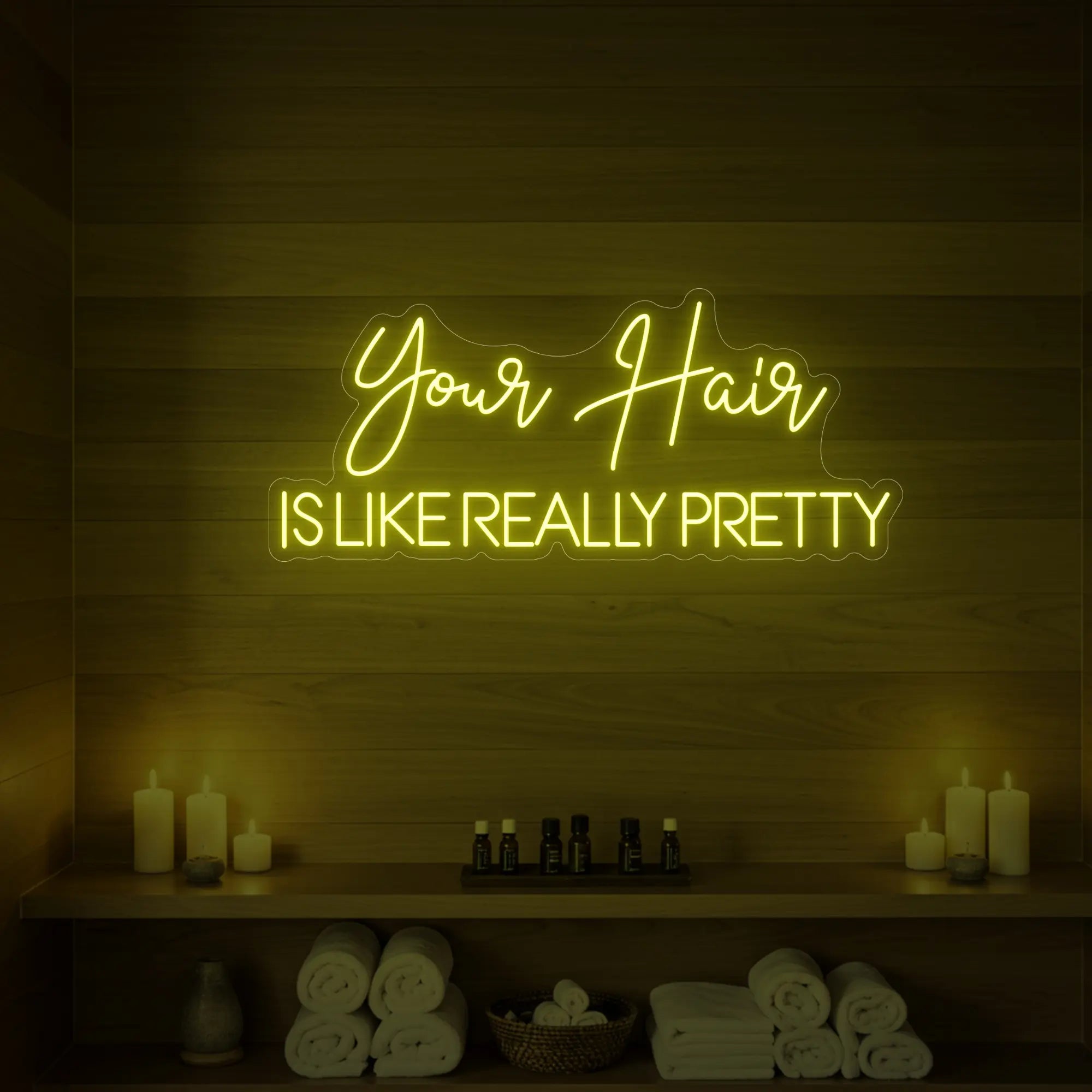 Photo of the 'Your Hair Is Like Really Pretty' neon sign glowing in lemon yellow against a styled interior wall.