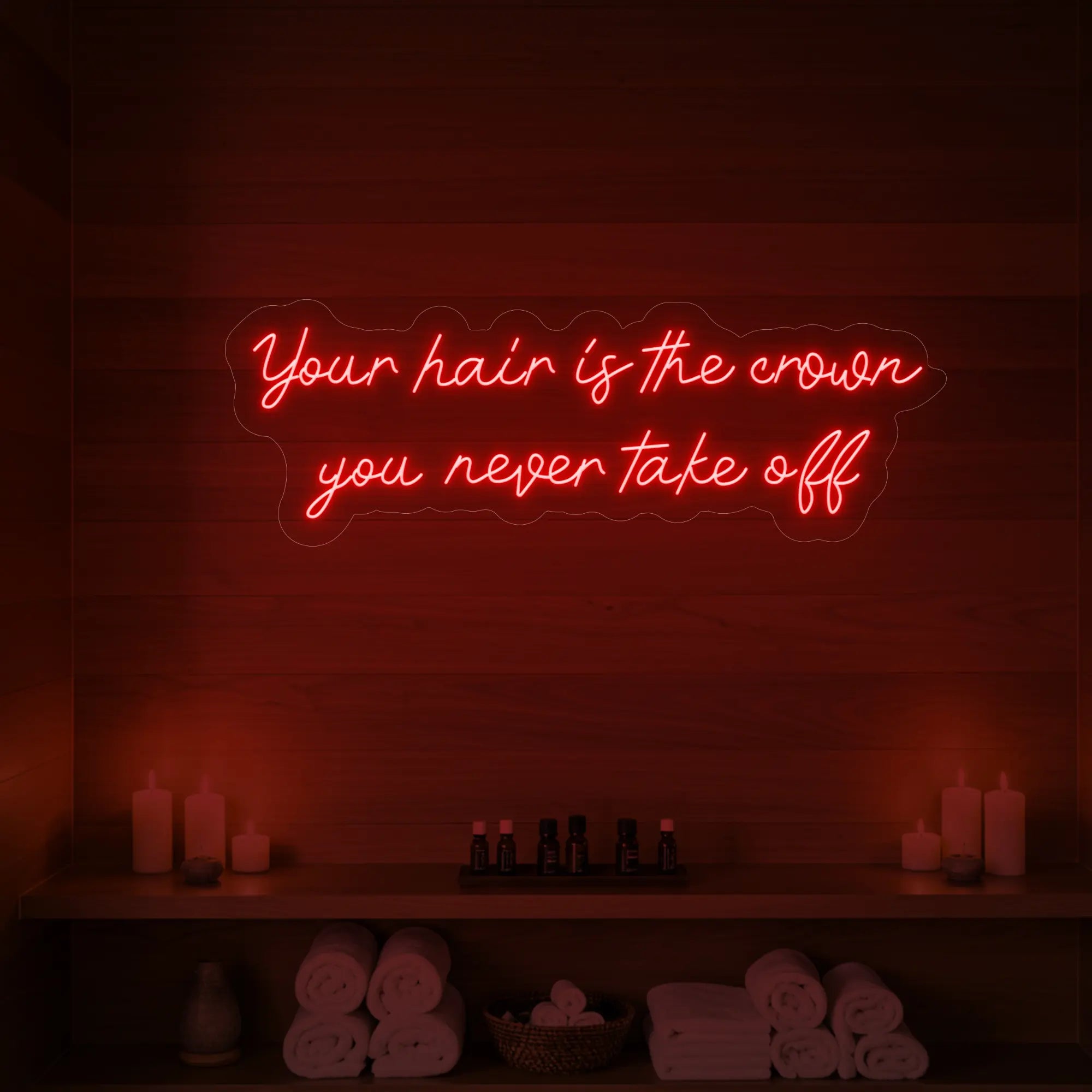 Photo of the 'Your Hair Is The Crown You Never Take Off' neon sign glowing in red against a styled interior wall.