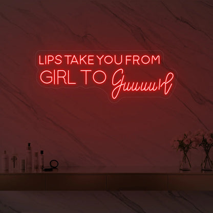 Photo of the 'LIPS TAKE YOU FROM GIRL TO Guuuurl' neon sign glowing in red against a styled interior wall.