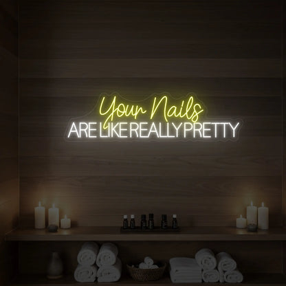 Photo of the 'Your Nails Are Like Really Pretty' neon sign glowing in lemon yellow against a styled interior wall.