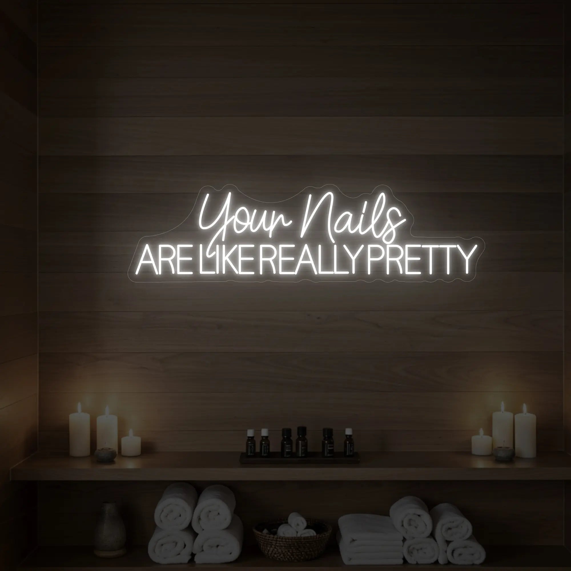 Photo of the 'Your Nails Are Like Really Pretty' neon sign glowing in cool white against a styled interior wall.

